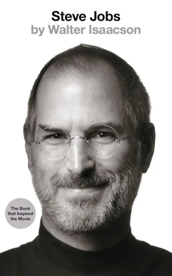 a man with glasses smiling - Steve Jobs by Walter Isaacson